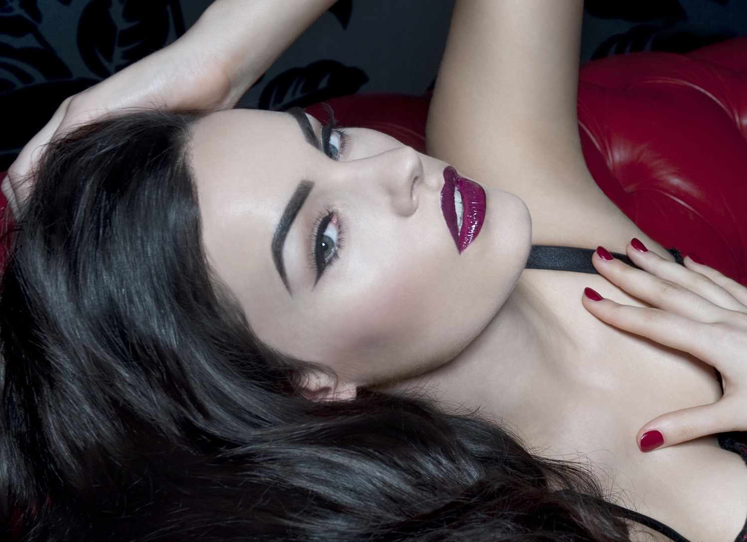 A woman with dark hair and purple lipstick.