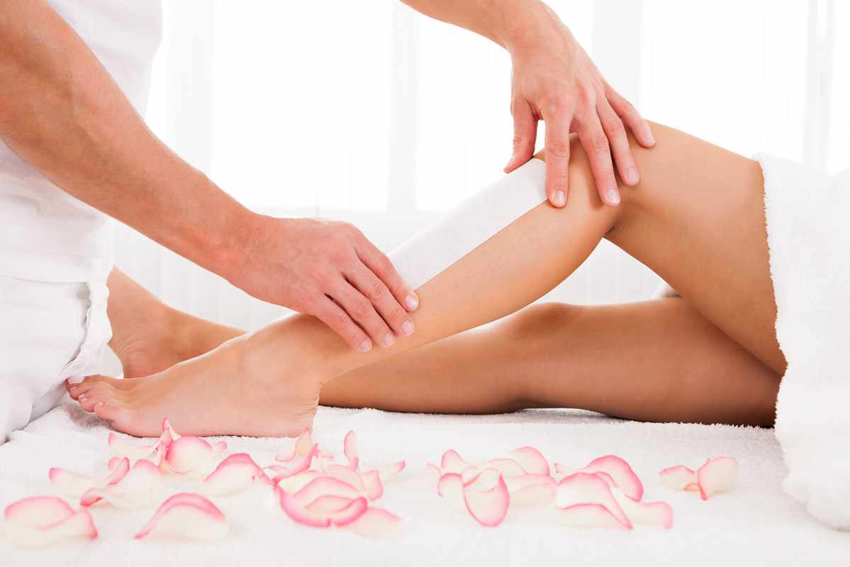 A person is waxing their legs with wax strips.