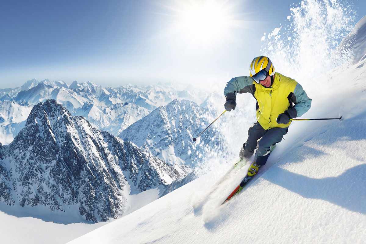 A man riding skis on top of a snow covered slope.