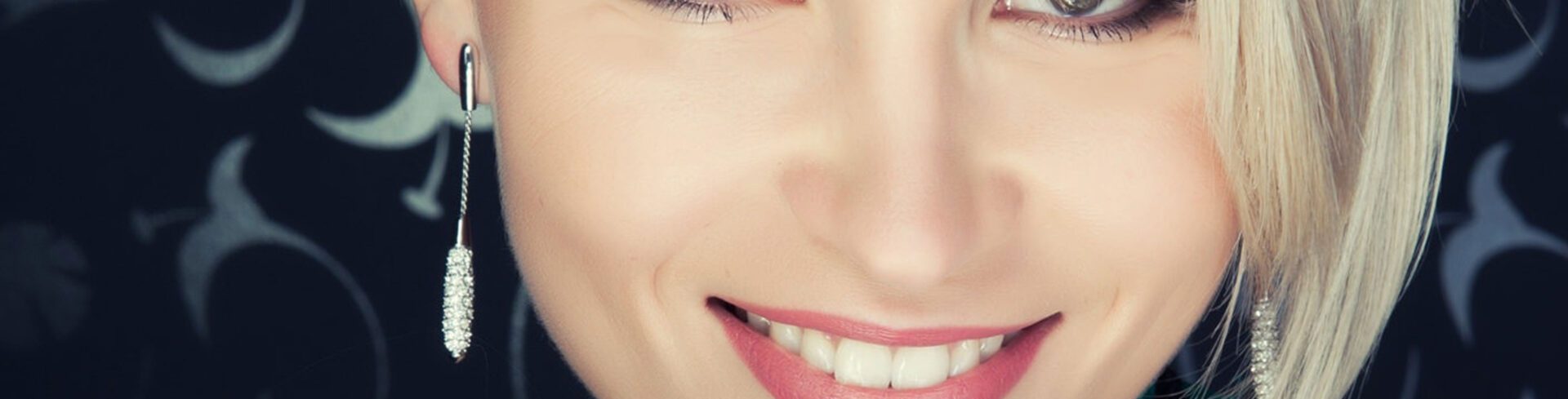 A close up of a woman 's smile with pink lips