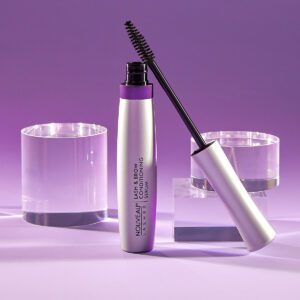 A bottle of mascara next to two glasses.